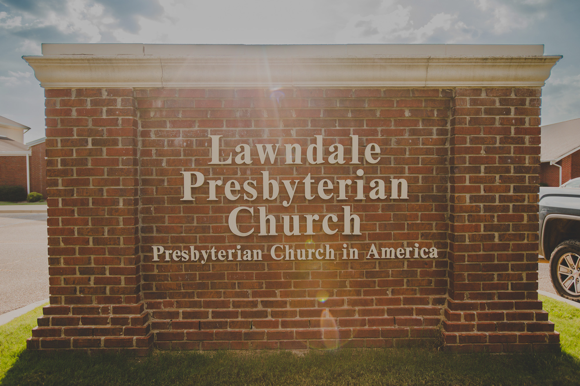 The brick monument sign at the church entrance reading Lawndale Presbyterian Church, Presbyterian Church in America